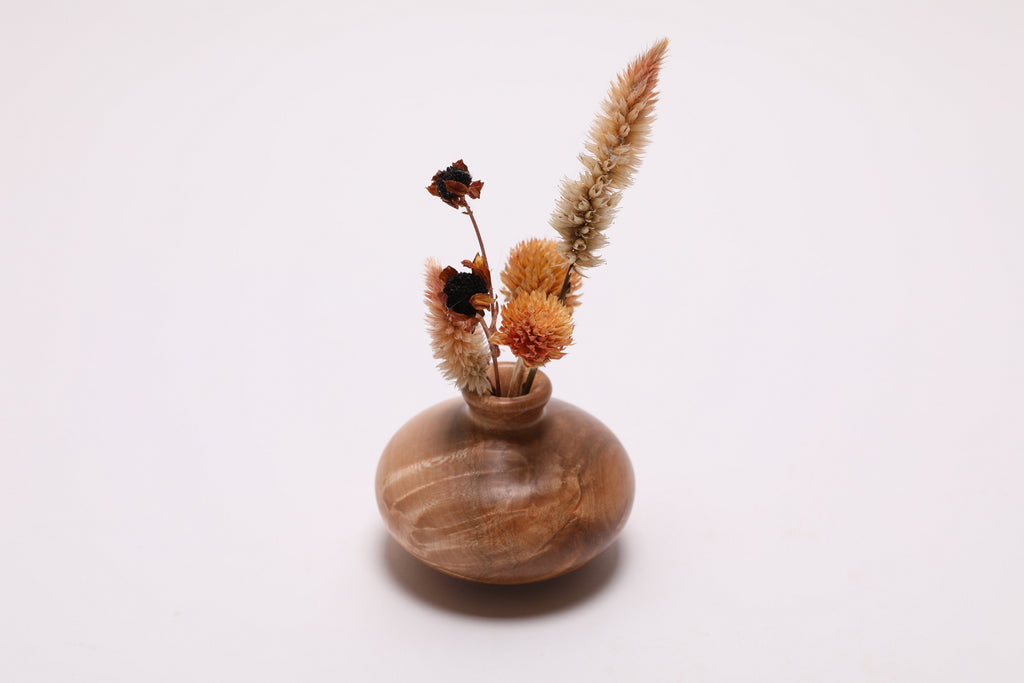 Handcrafted maple burl dry vase side view displaying 2 3/8 inch height and dense wood grain with dried flowers