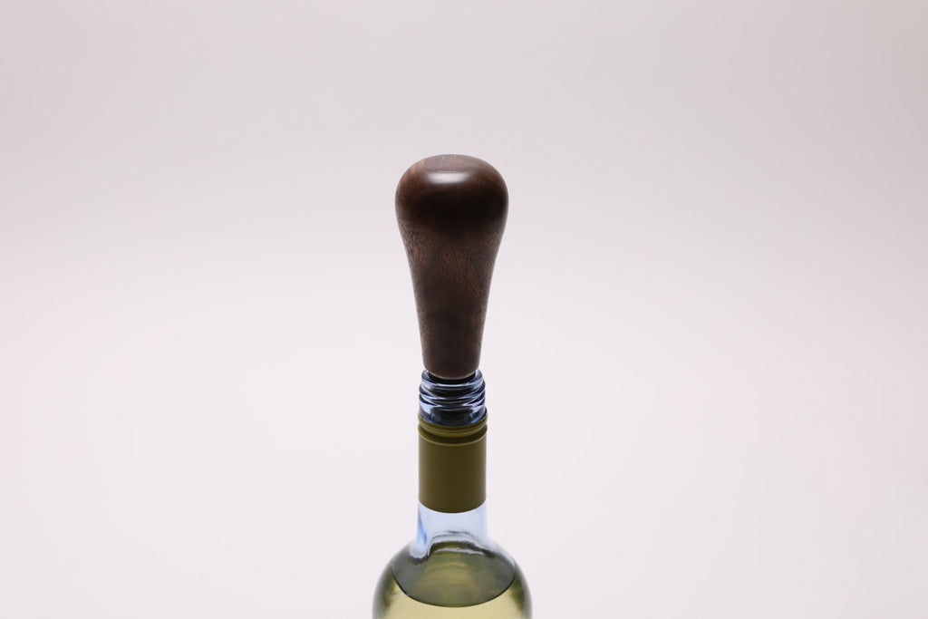 Black walnut burl bottle stopper detail showing stainless steel construction and nitrile O-rings