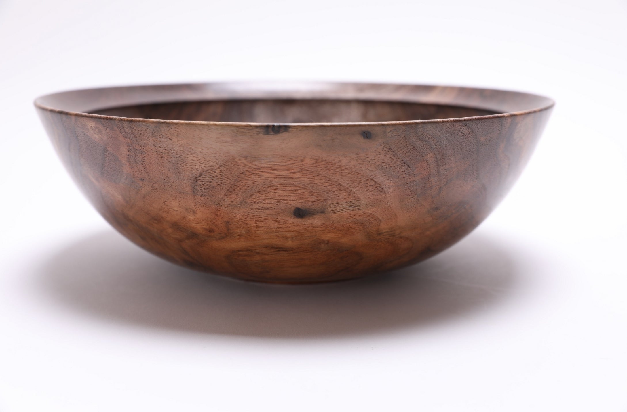 Curly black walnut bowl craftsmanship detail highlighting rare figured grain and growth ring transition lines