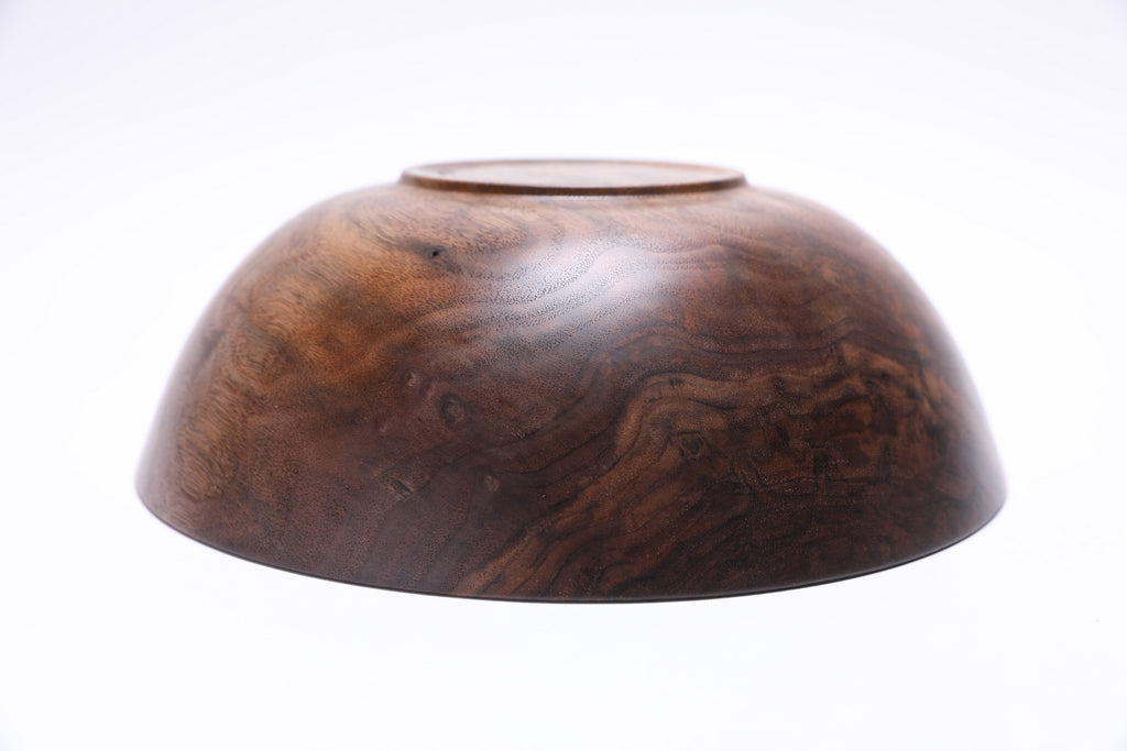 Curly black walnut wooden bowl angle shot displaying unique bud scars and chatoyant figured wood grain
