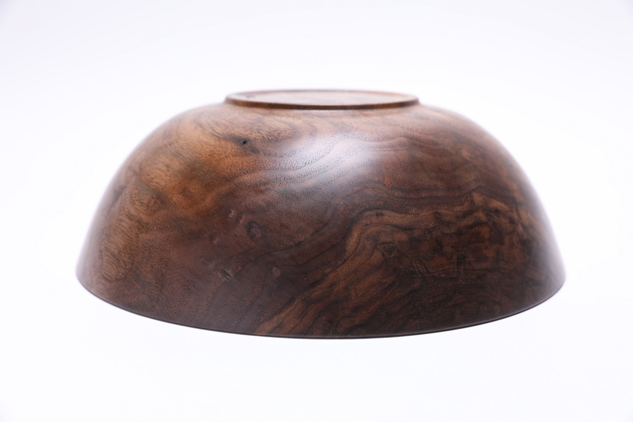 Curly black walnut wooden bowl angle shot displaying unique bud scars and chatoyant figured wood grain
