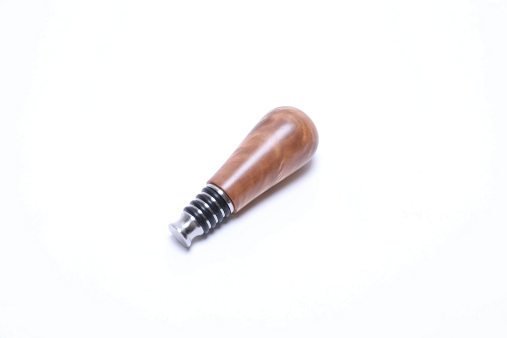 Handcrafted maple burl bottle stopper side view displaying natural quilt grain patterns