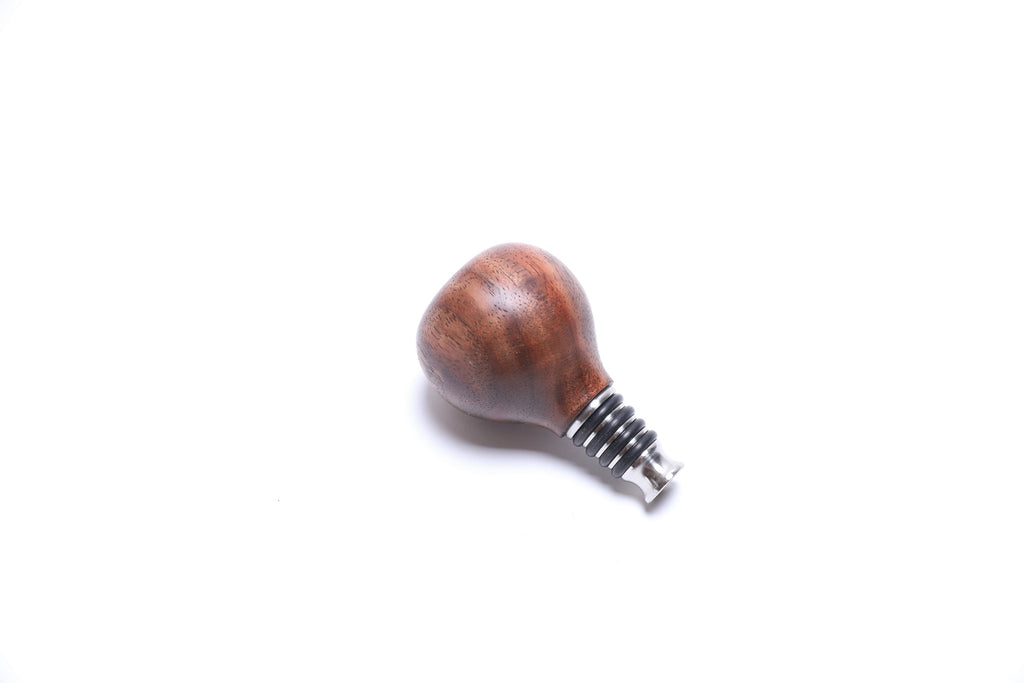 Walnut burl wine stopper showing red highlights and dark chocolate brown stripes with stainless steel base
