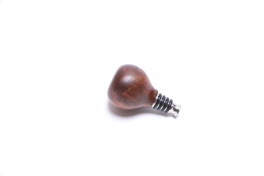 Handcrafted walnut burl bottle stopper side view displaying natural wood grain and unique character