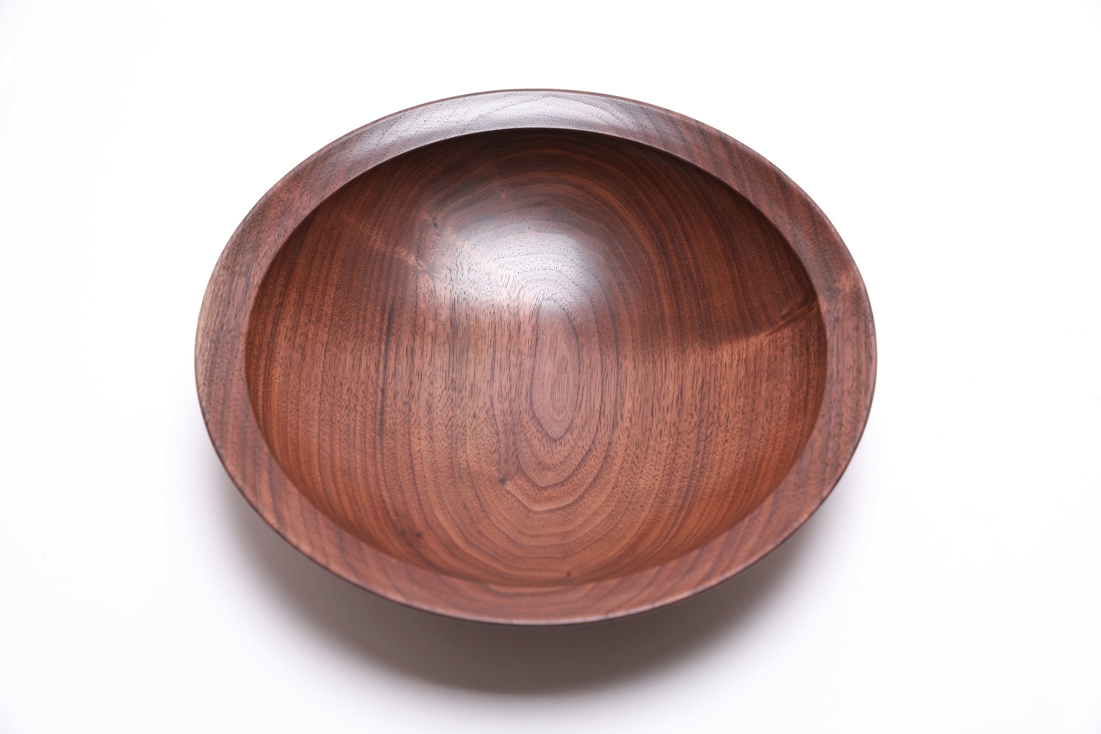 Handcrafted black walnut bowl side view displaying 2 1/4 inch depth and curved taper rim 