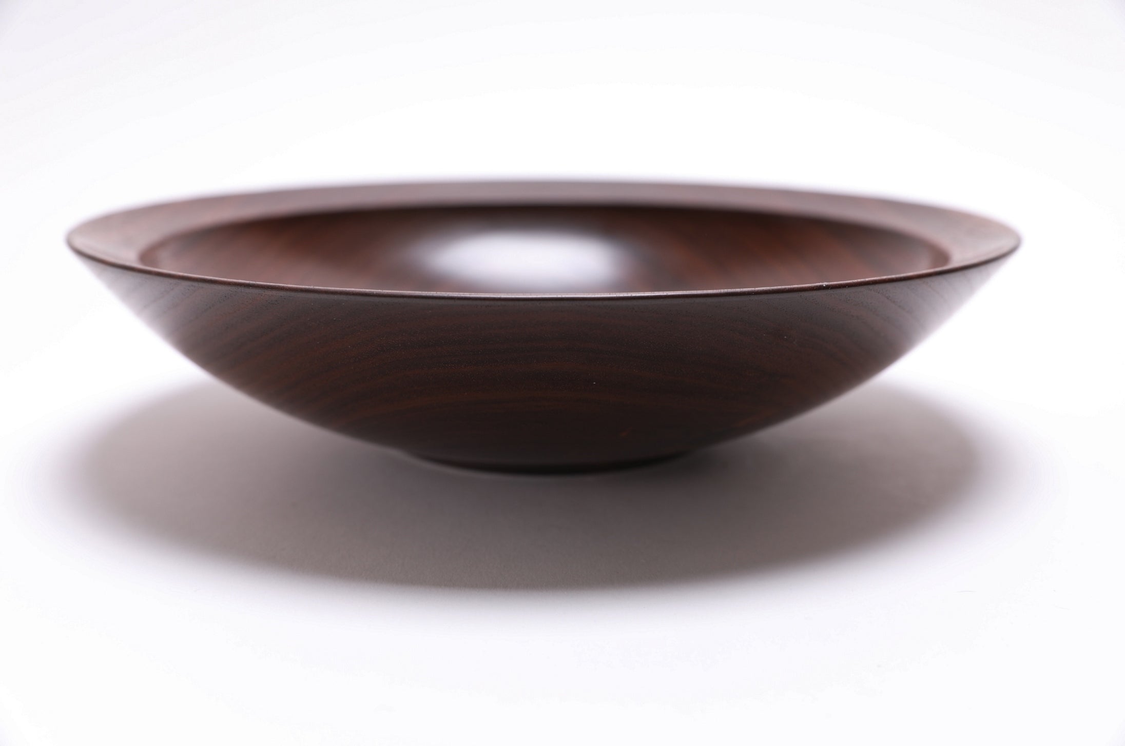 Handcrafted black walnut bowl 9 3/4 x 2 1/4 inches showing rounded curved taper rim