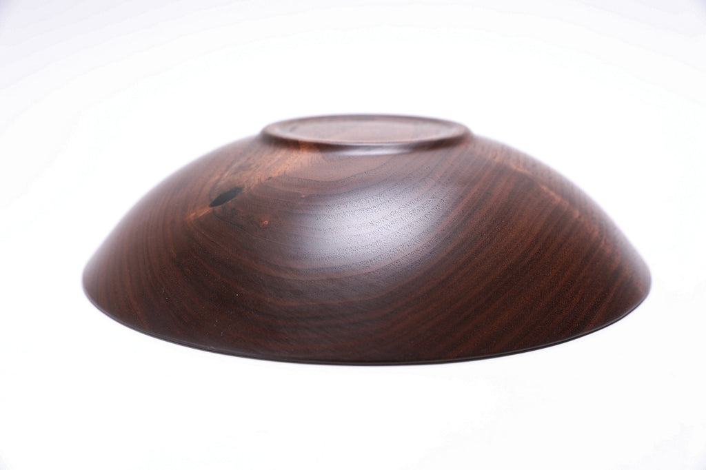 Wild black walnut wood bowl angle shot displaying raised foot and artisan quality 