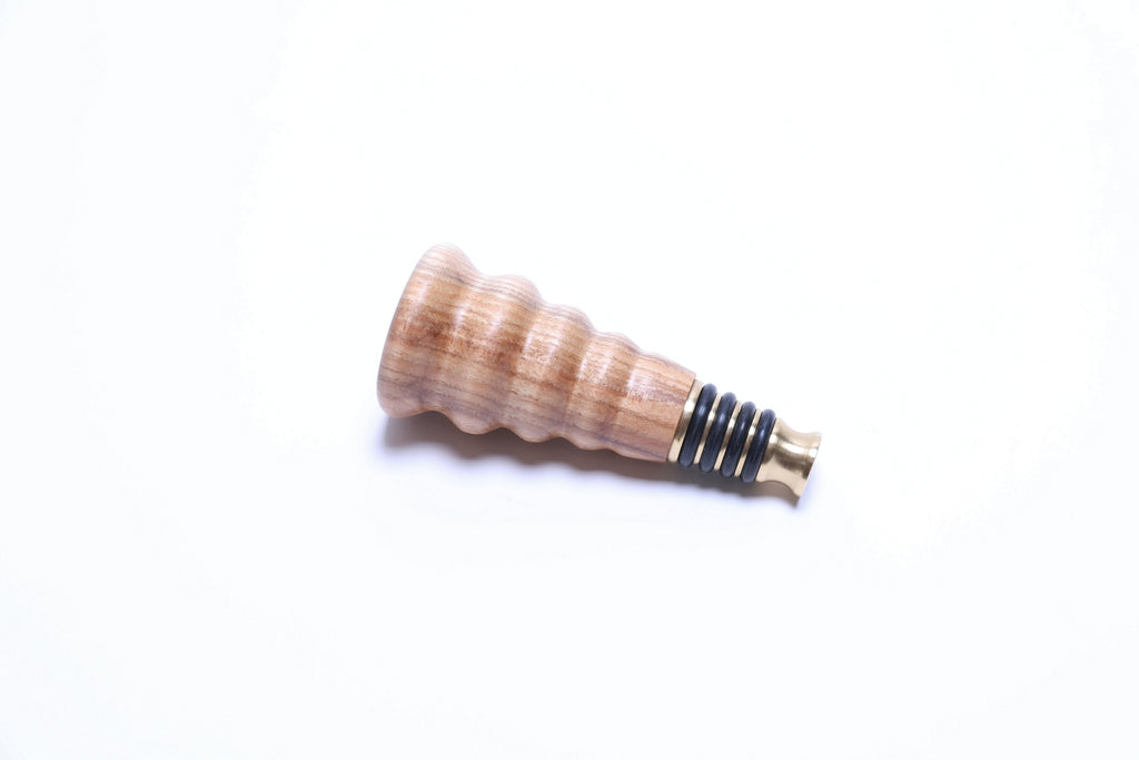 Side view of hickory wine stopper with premium solid brass base