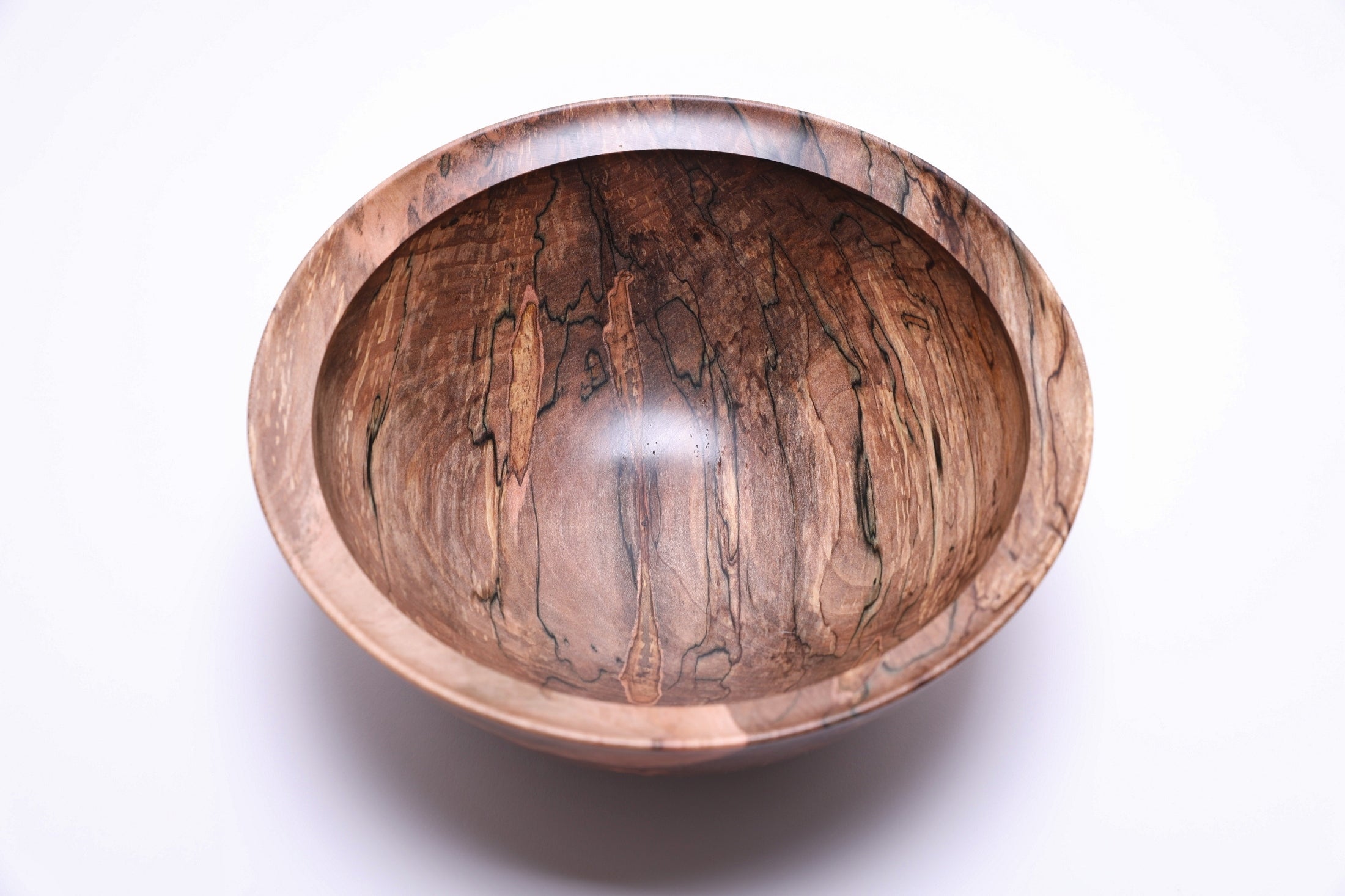 Close-up of spalted maple wood grain showing ink black transition lines and vibrant colors