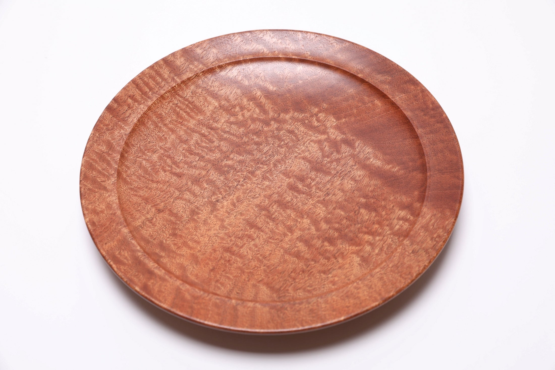 Close-up of pommele sapele wood grain with iridescent chatoyant figure from African sapele