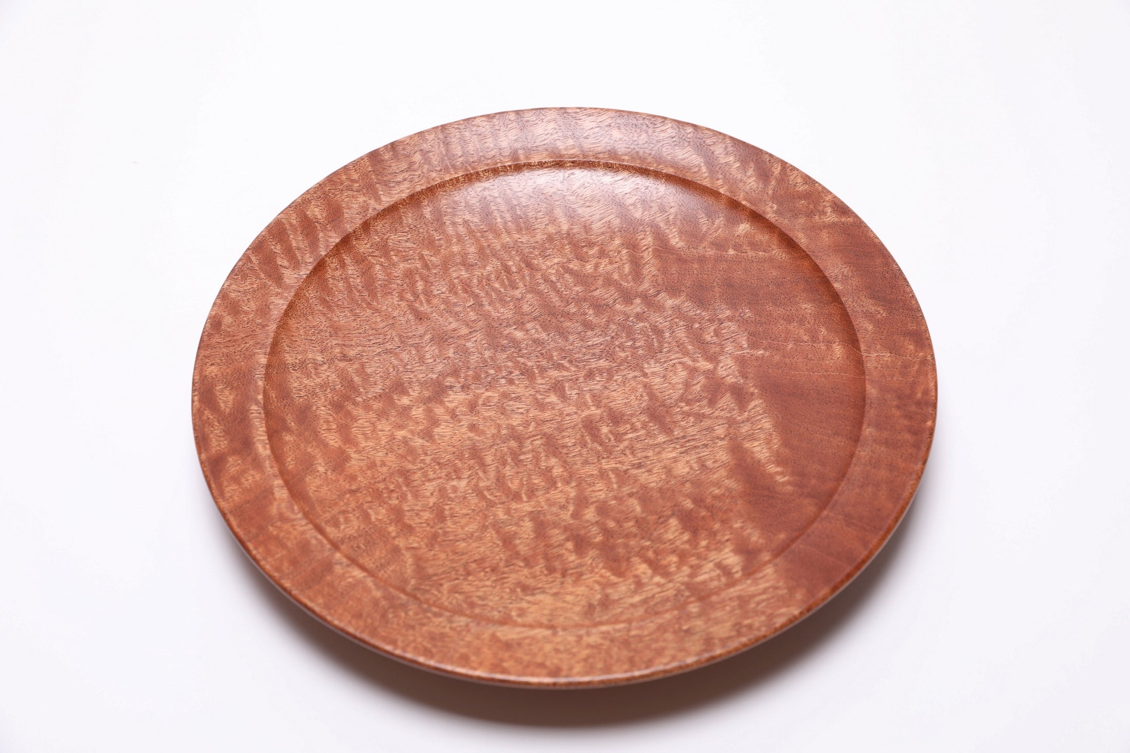 Undercut rim detail of handmade pommele sapele shallow bowl with raised foot