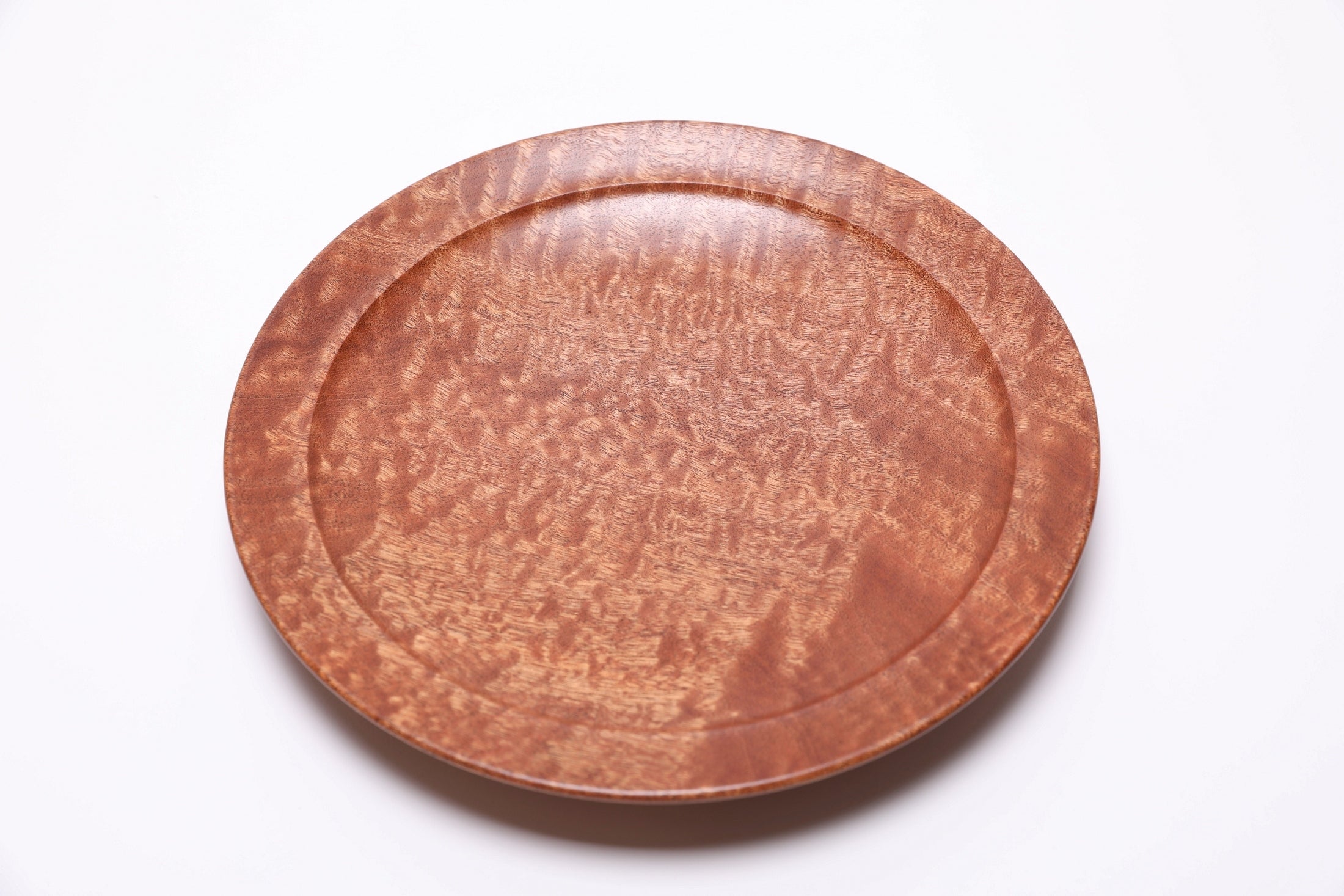 Interior of pommele sapele wooden bowl with smooth food-safe natural oil finish
