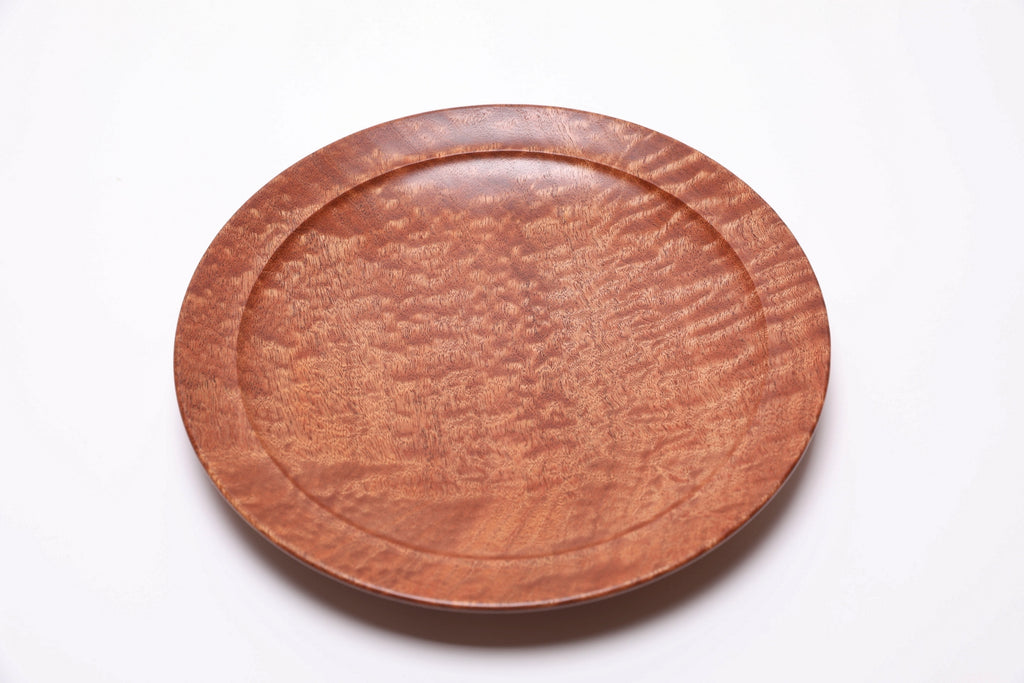 Detail of chatoyant sapele wood surface showing shifting light and dappled figure
