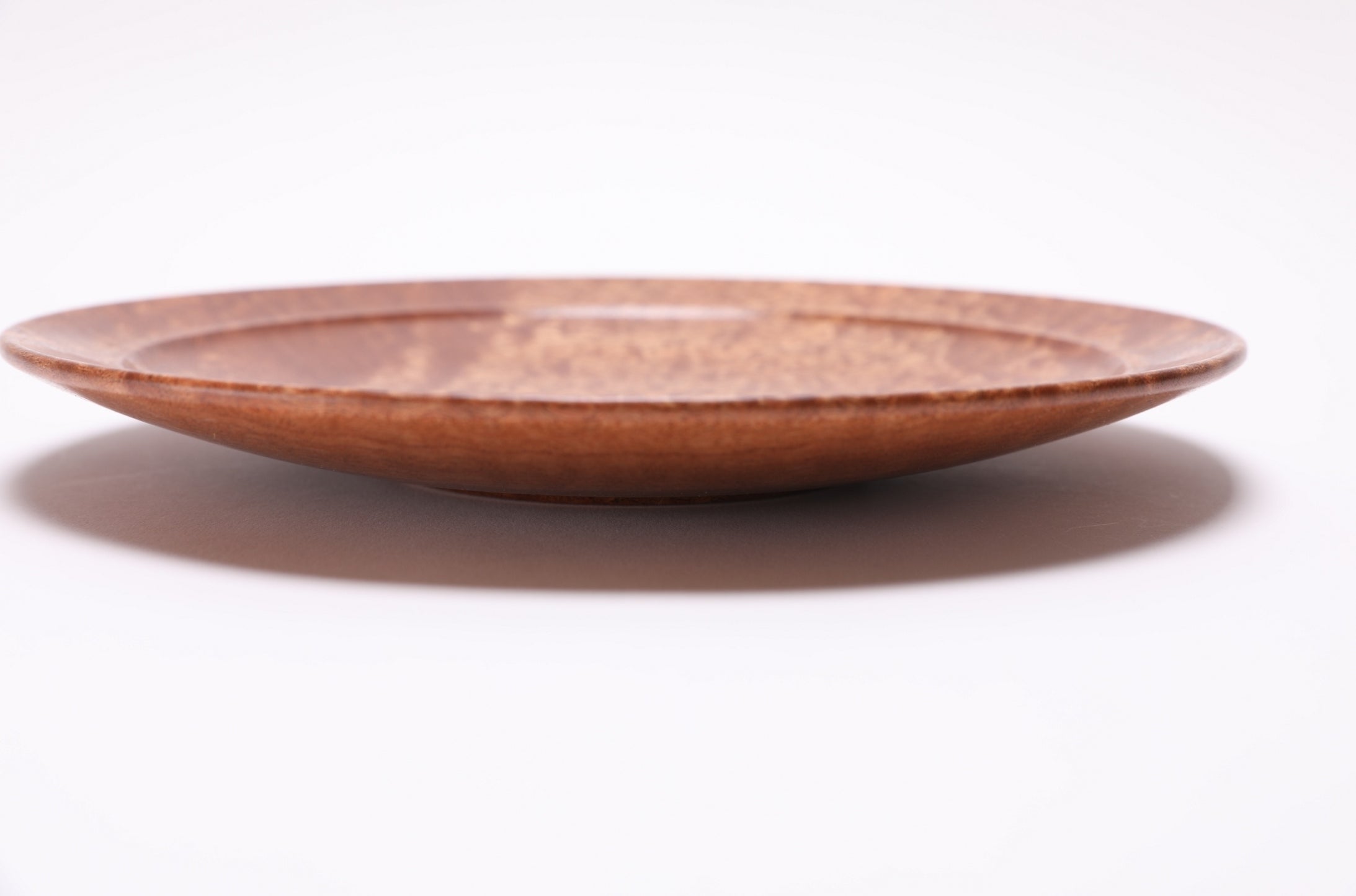 Side profile of pommele sapele bowl, 9¾ inches by 1¾ inches, handcrafted in North Carolina