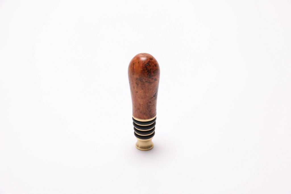 Top view of black cherry burl bottle stopper showing swirling burl and birdseye pattern