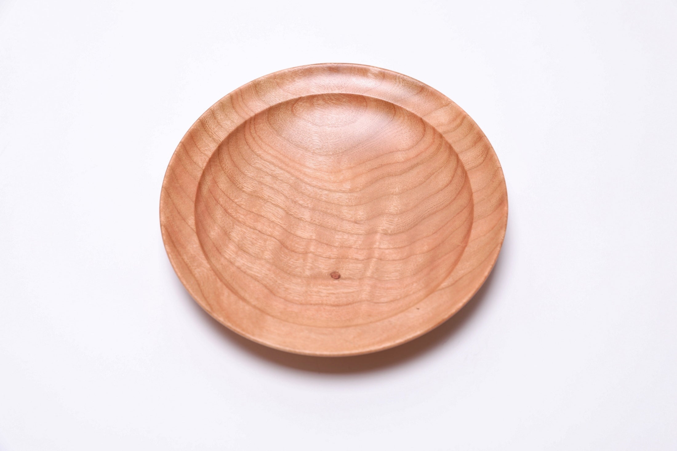 Close-up of quilted black cherry wood grain showing chatoyant shimmer in light