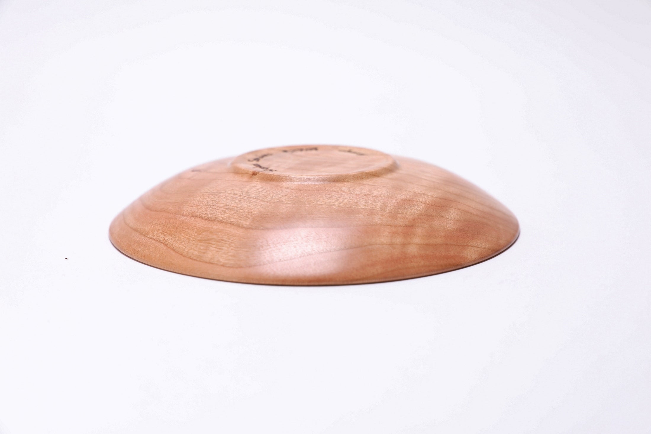 Upside down side view of handmade black cherry jewelry dish with curved taper and rounded over rim