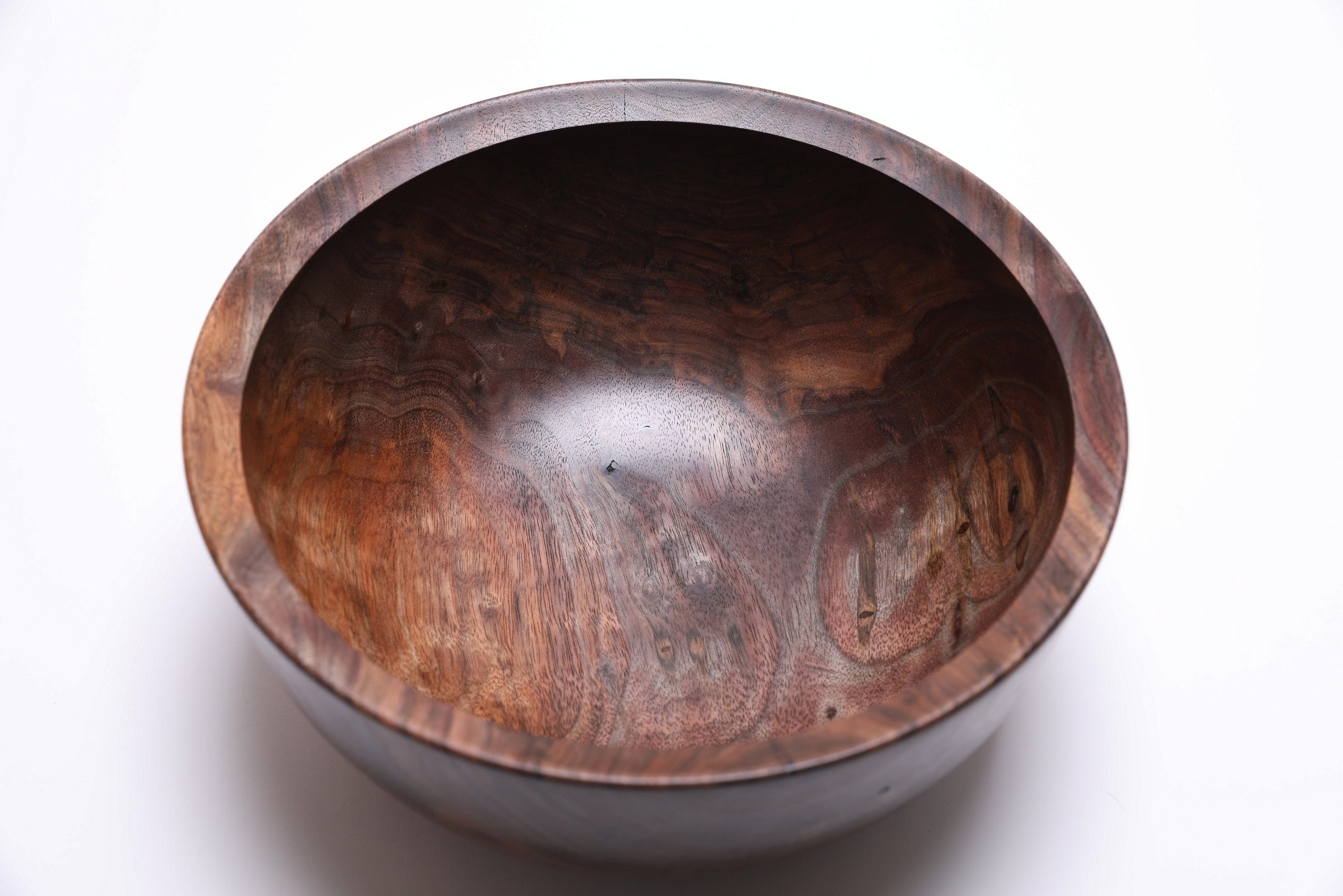 Handcrafted walnut bowl with rich dark chocolate and red highlight tones