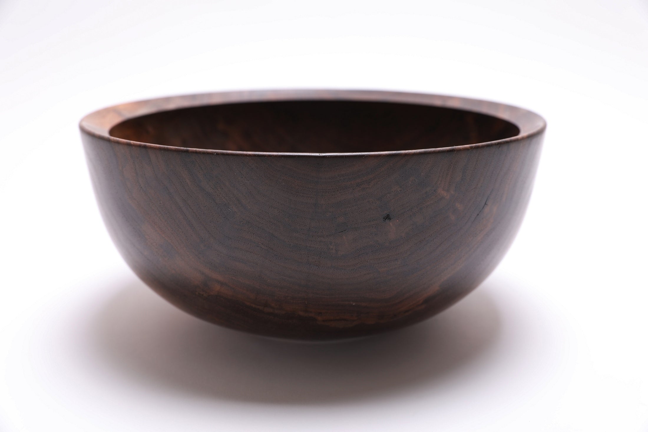 Handcrafted spalted walnut bowl, angled view highlighting curly grain and bud scars