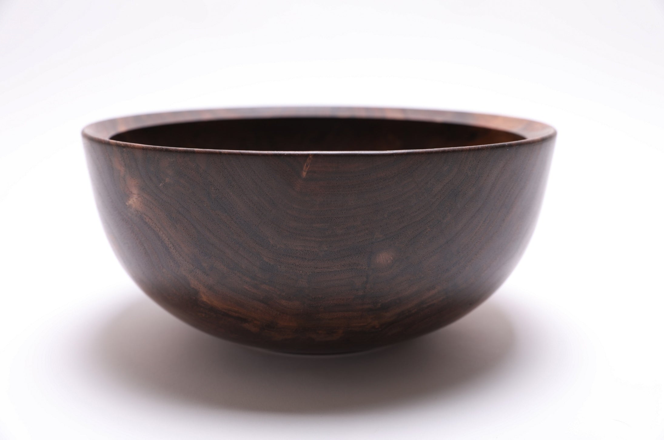 Spalted black walnut wooden bowl, close-up of cream to amber color variation