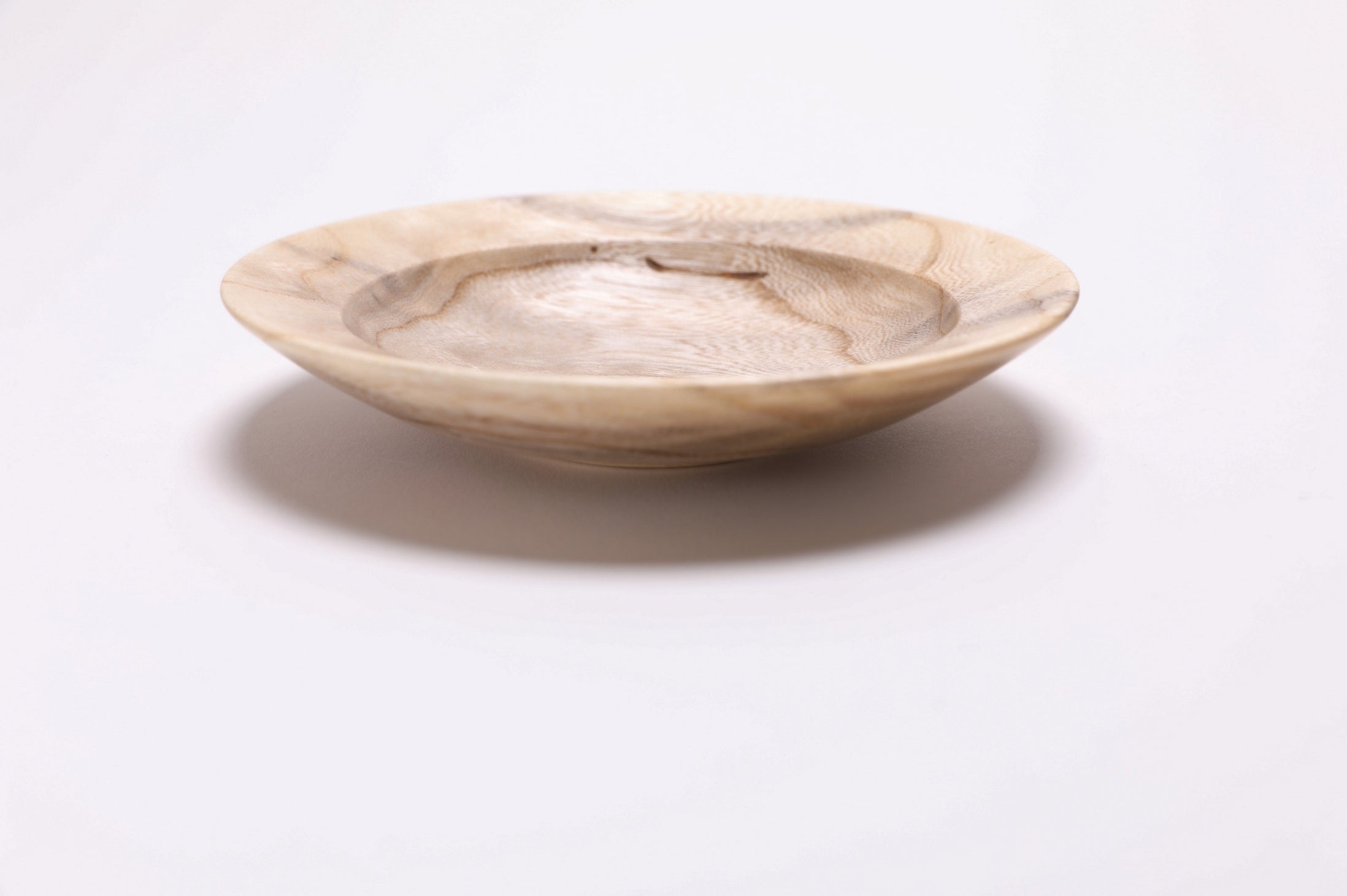 Ironwood ring dish with undercut rim and raised foot, side profile