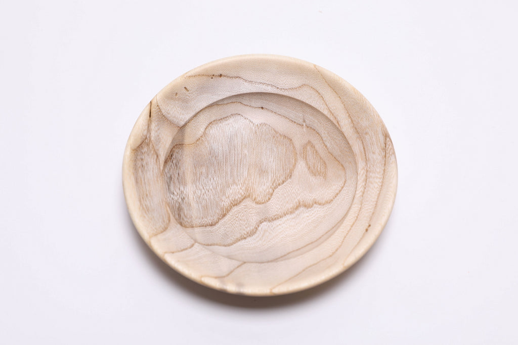 Close-up of hackberry wood jewelry dish showing beetle holes and curly growth rings