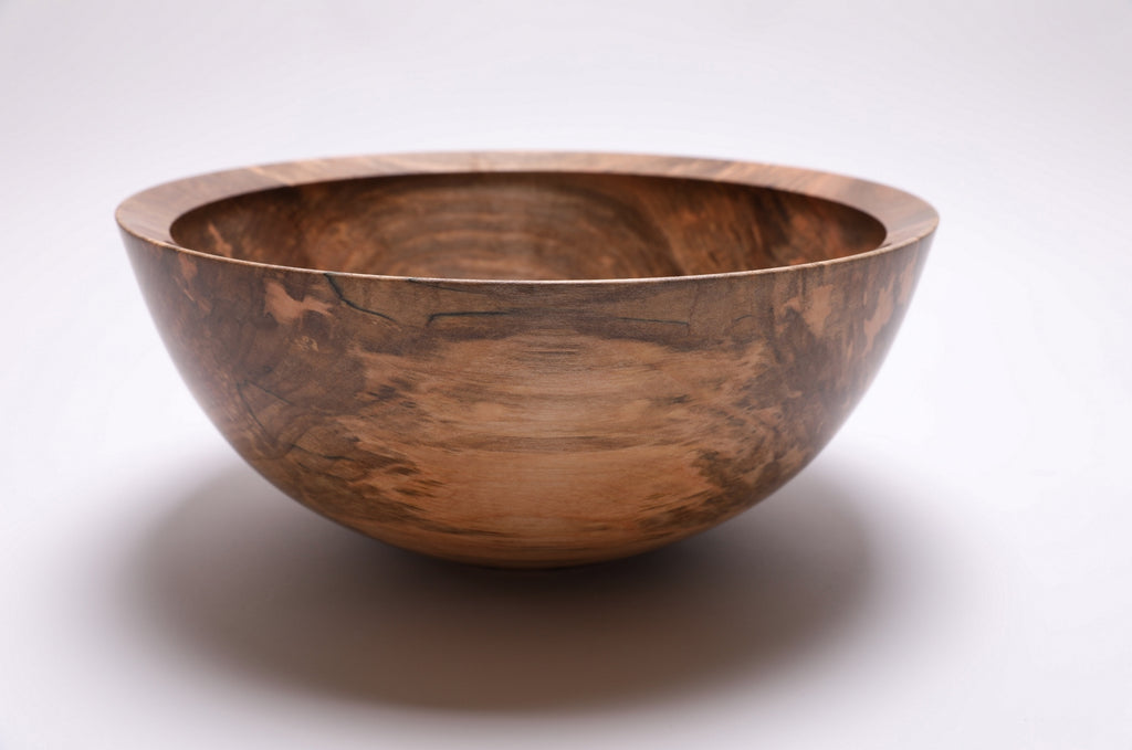 Side profile of large spalted maple salad bowl showing curved taper, undercut rim, and raised foot