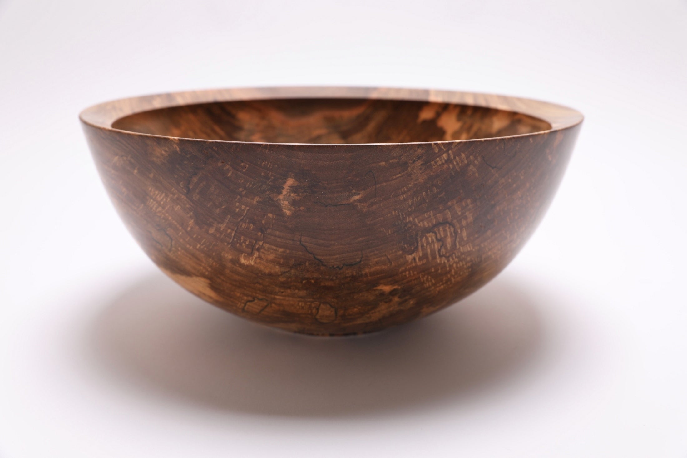 Angled view of handcrafted spalted sugar maple bowl, 5¾" deep, with food-safe oil finish