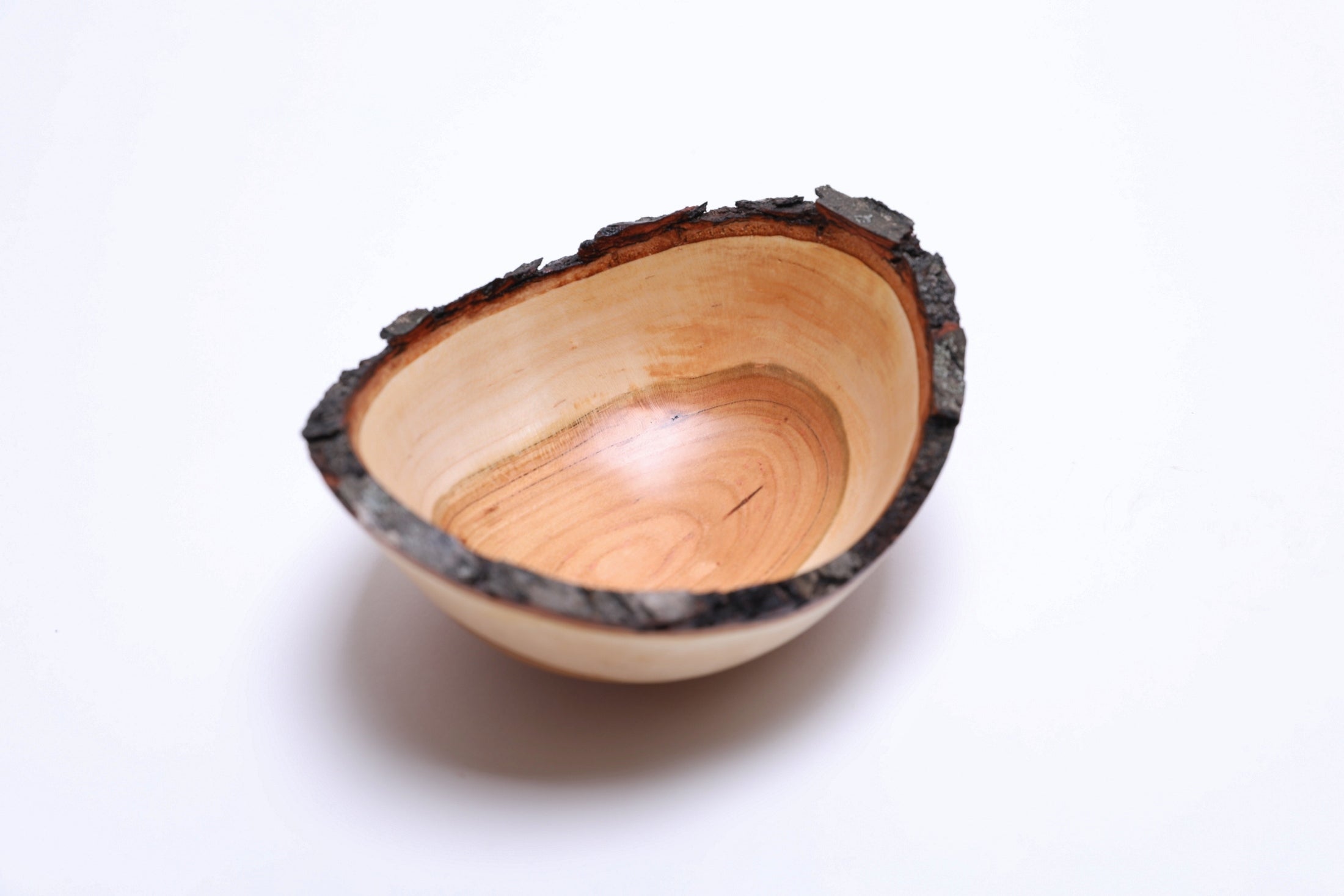 Wild black cherry wooden bowl with natural bark rim, top view
