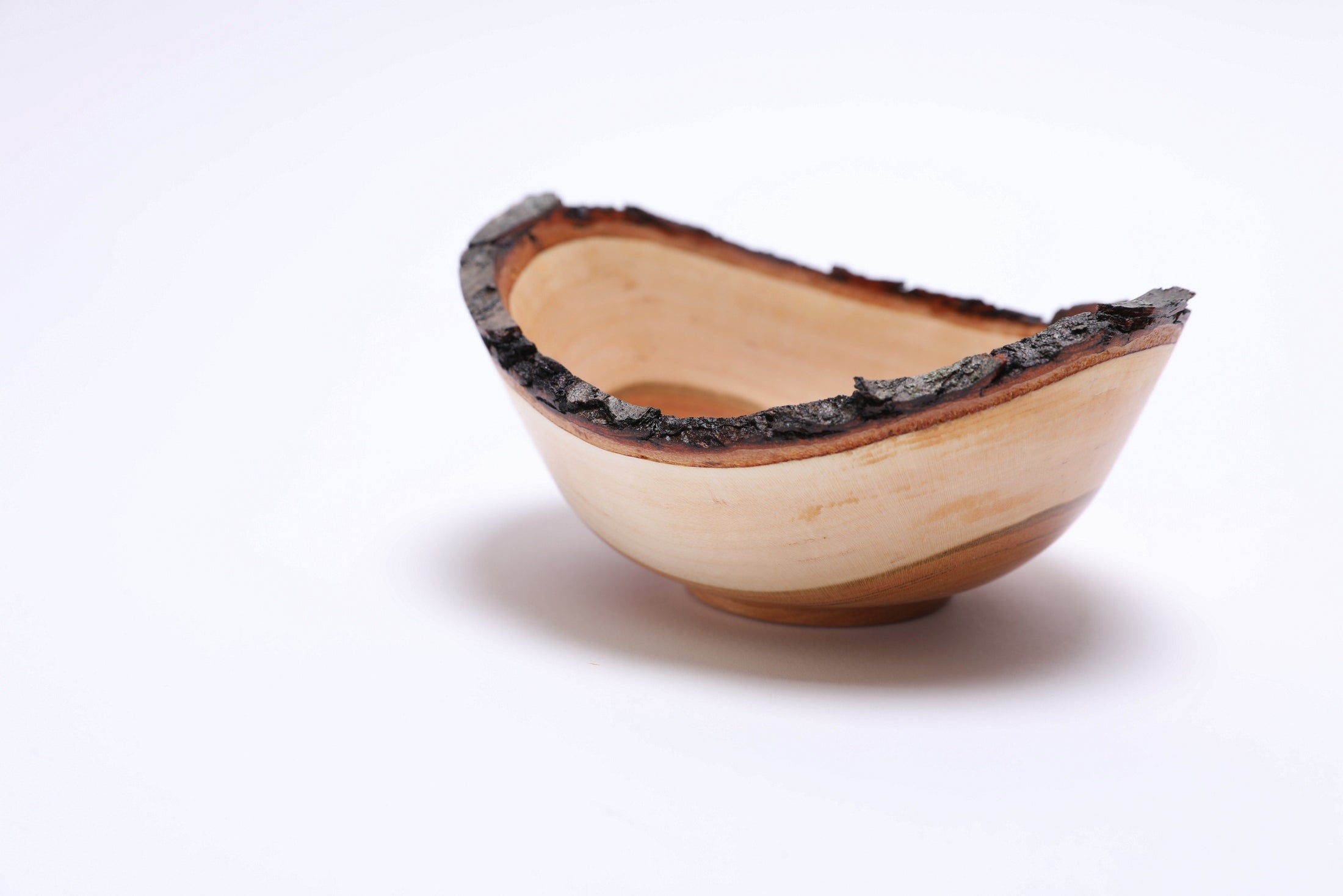 Small wild black cherry bowl with intact natural bark edge, angled view