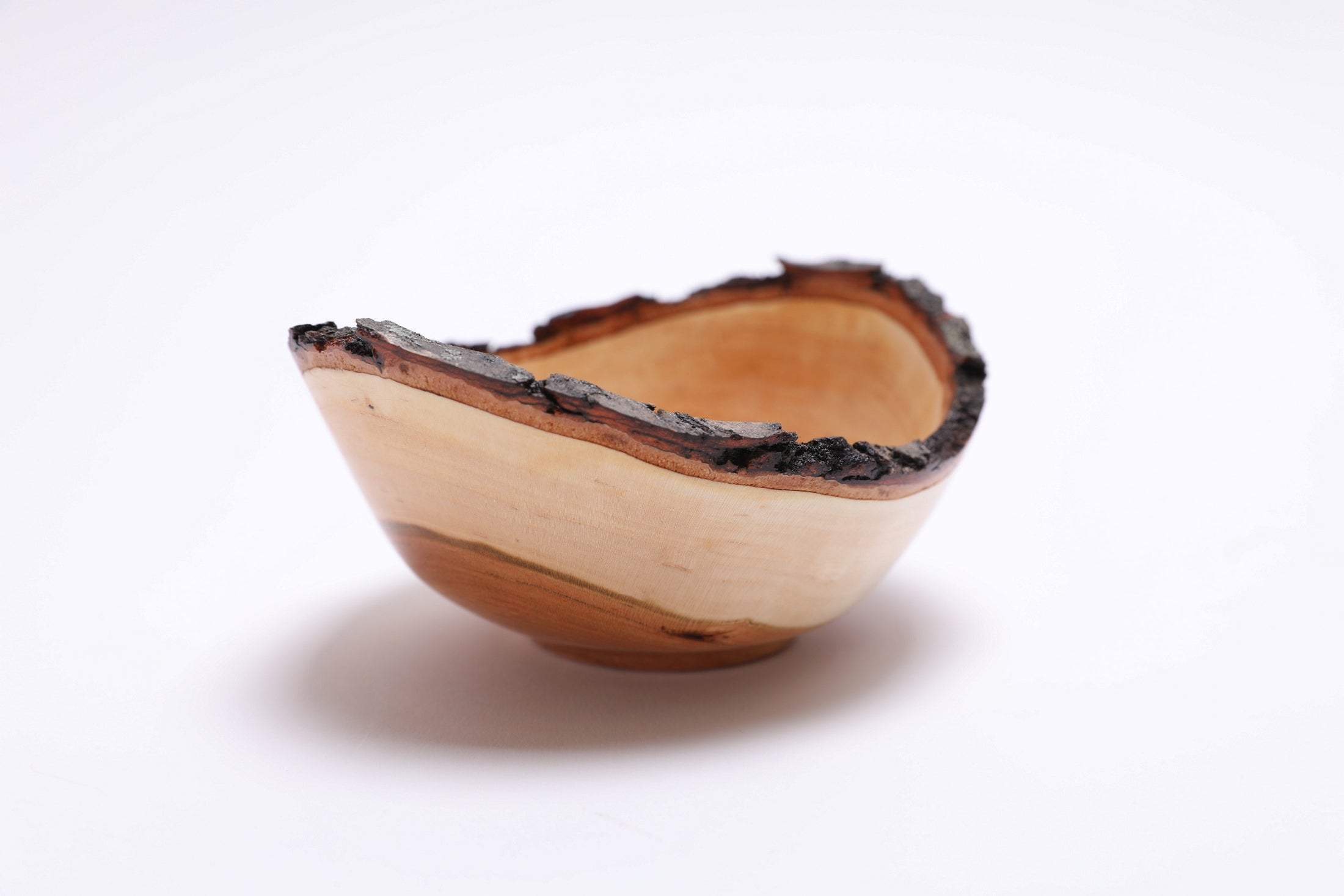 Natural edge black cherry bowl showing bark-to-heartwood color rings, side view