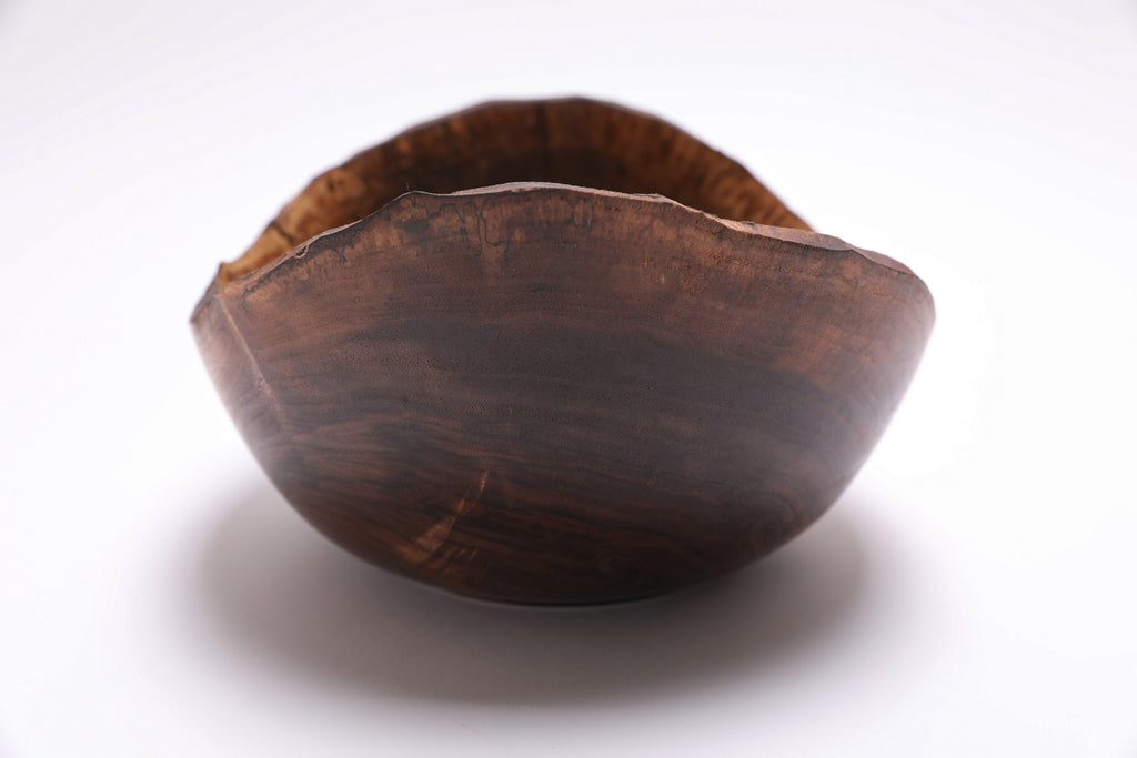 Spalted black walnut bowl — side view showing natural edge and bark loss area