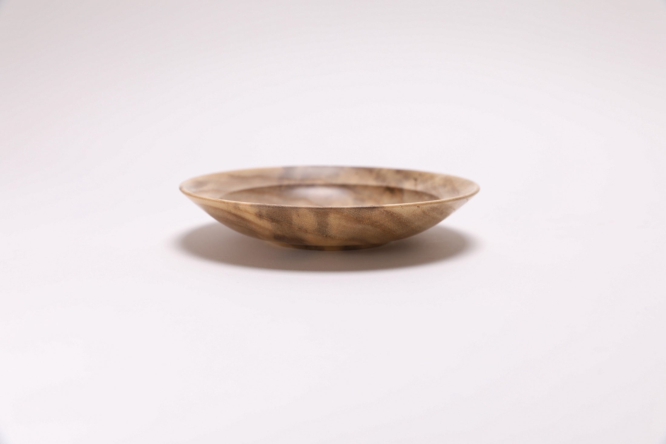 Handmade hackberry wood dish — side  view showing cream, gray, and amber grain tones