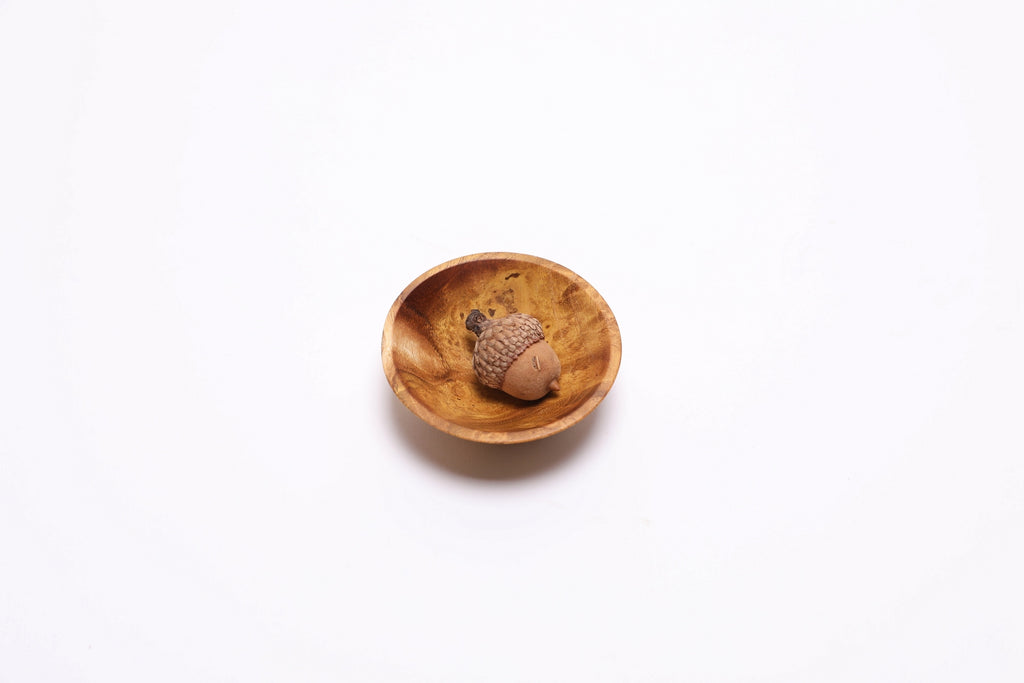 Mulberry burl bowl interior showing natural wood grain and finish with a acorn in the bottom for scale