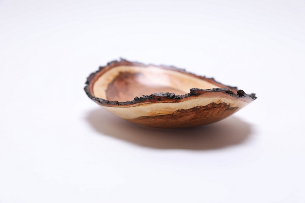 Natural edge wild black cherry bowl, angled side view highlighting figured heartwood ends and bark rim, Sanders Woodworking