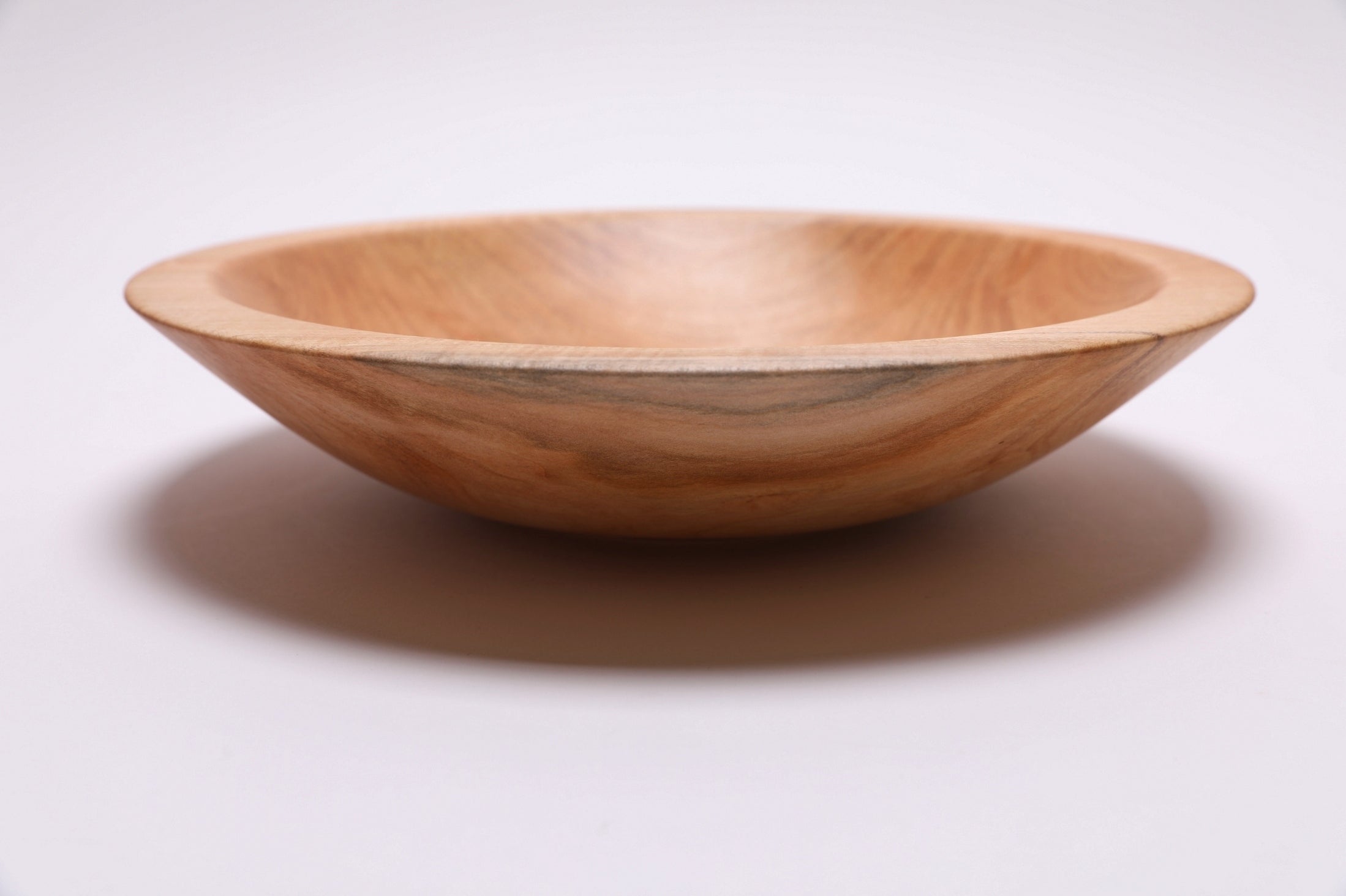 Side view of shallow sugar maple chopping bowl, 2 1/4 inches deep, natural edge profile