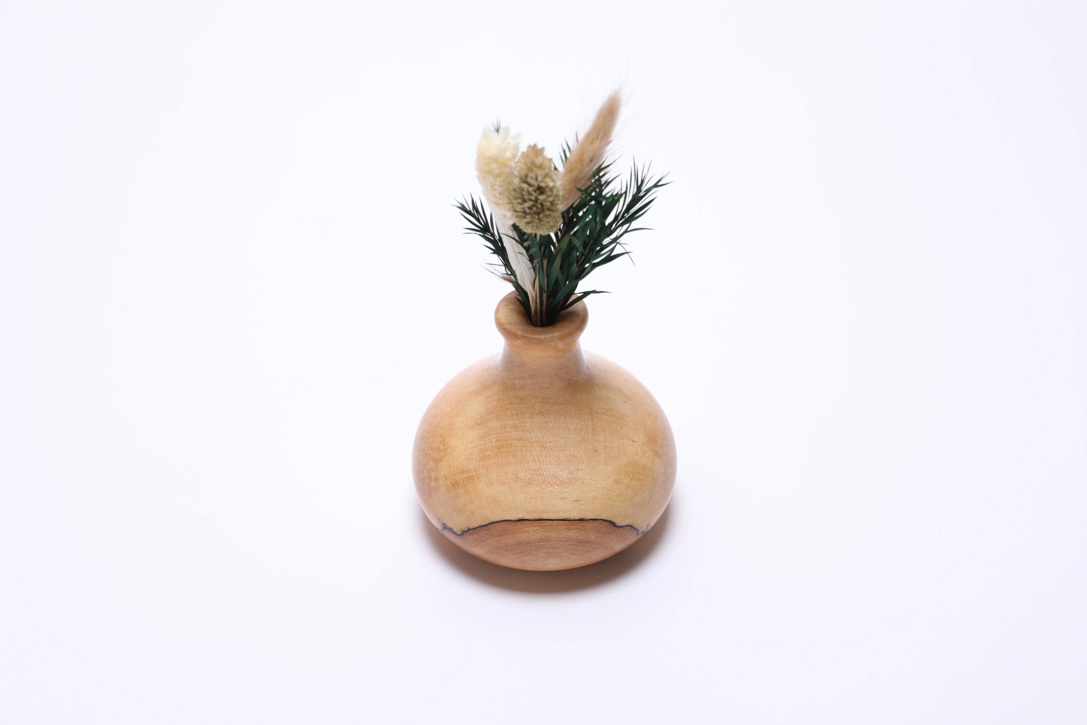 Spalted big leaf maple weed pot named Spot with dry flowers, angled side view, amber dot and ink-black spalting, Sanders Woodworking
