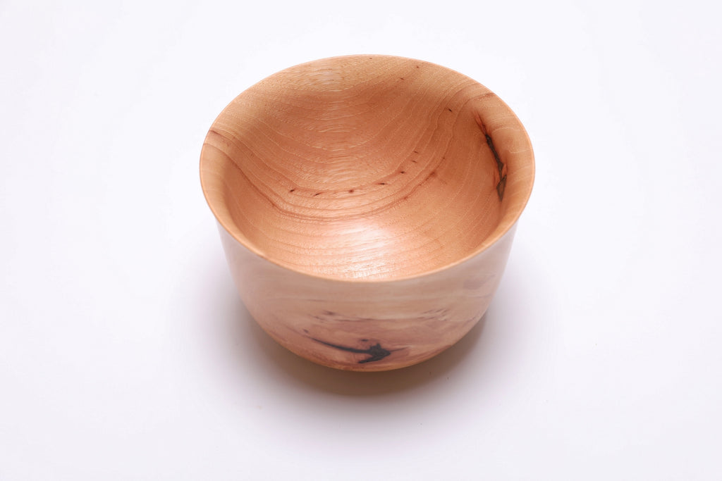 Angled view of pecan Liberty Bell bowl showing bell rim shape and bark inclusions