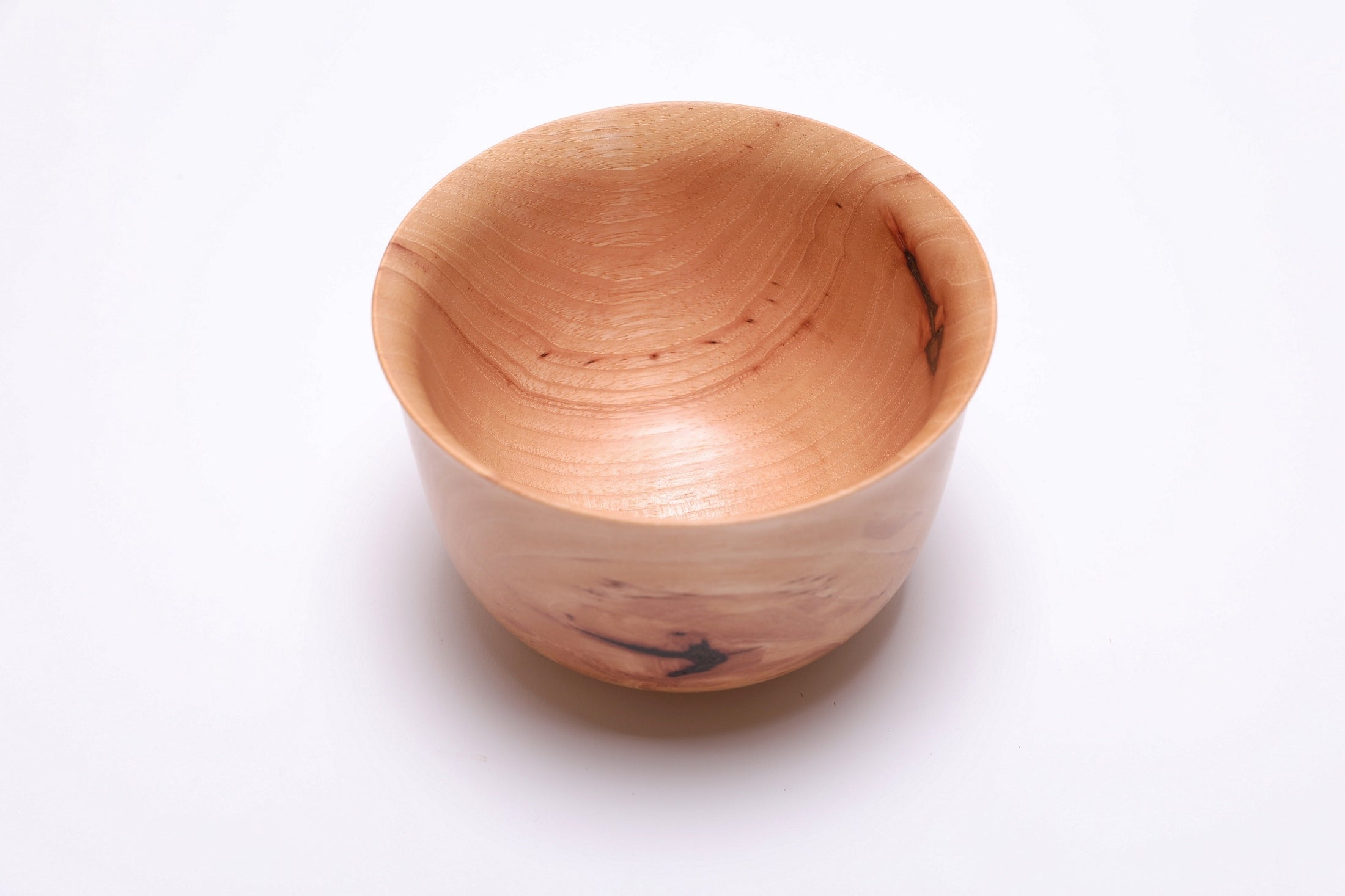 Angled view of pecan Liberty Bell bowl showing bell rim shape and bark inclusions