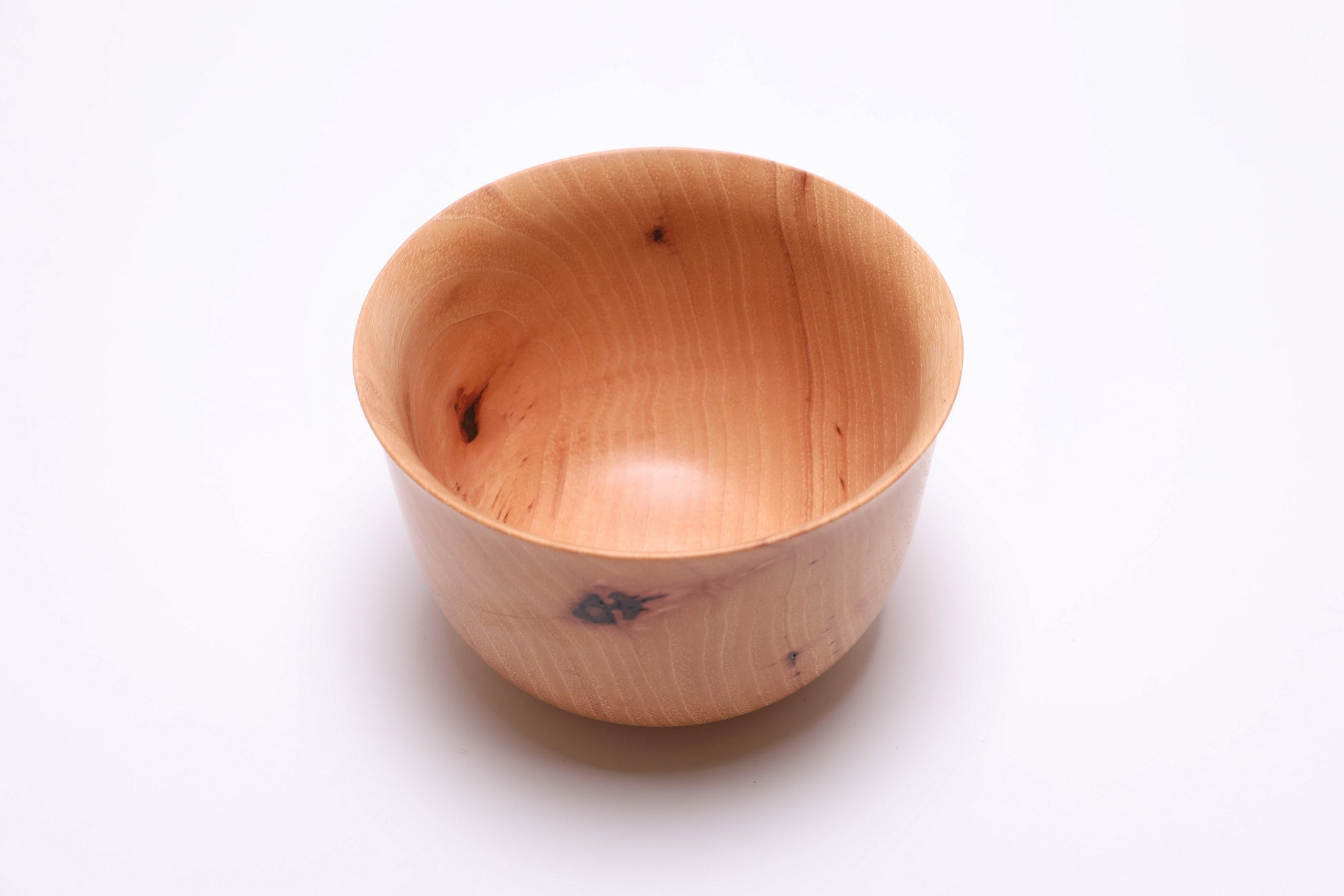 Angled overhead view of hand-turned pecan bowl with bud scars and natural oil finish