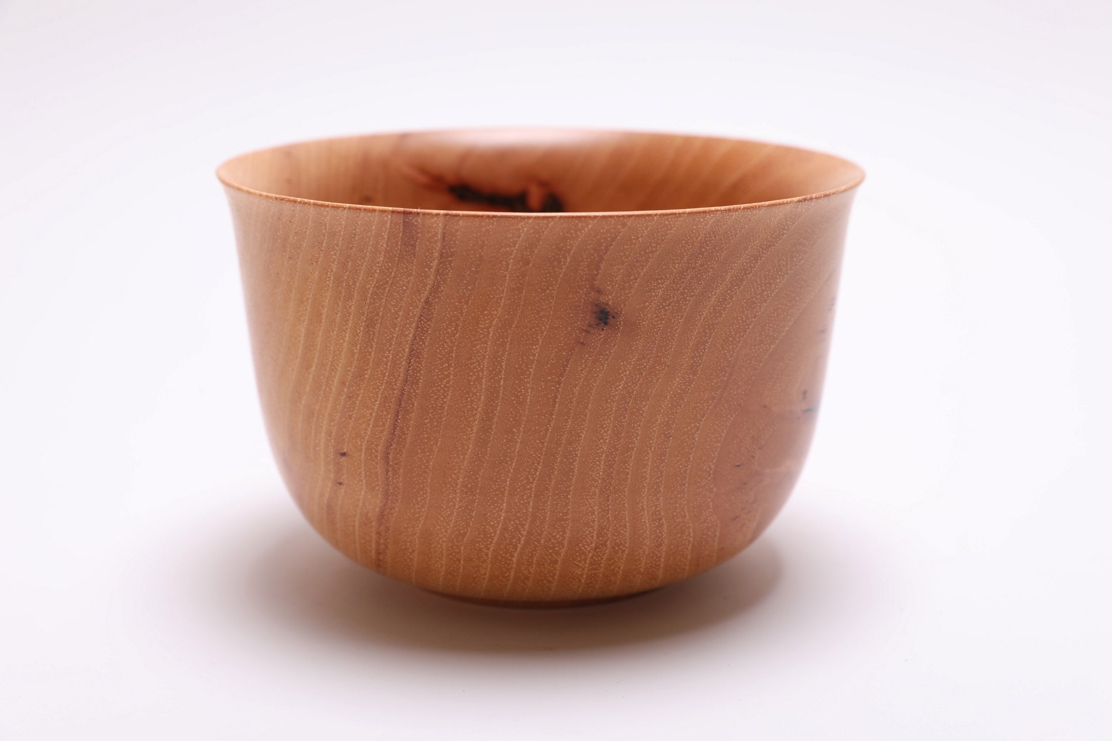 Side view of pecan wood bowl showing heavy bottom, raised foot, and natural wood grain