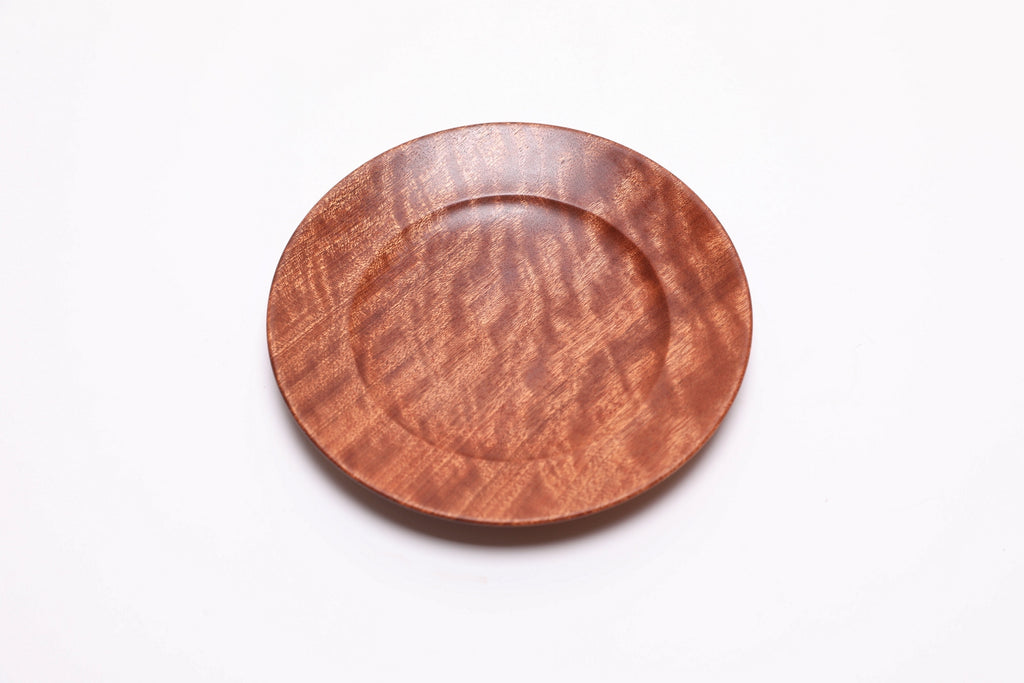 Wooden ring dish in quilted sapele, top view rotated 30°, curved taper and undercut rim visible