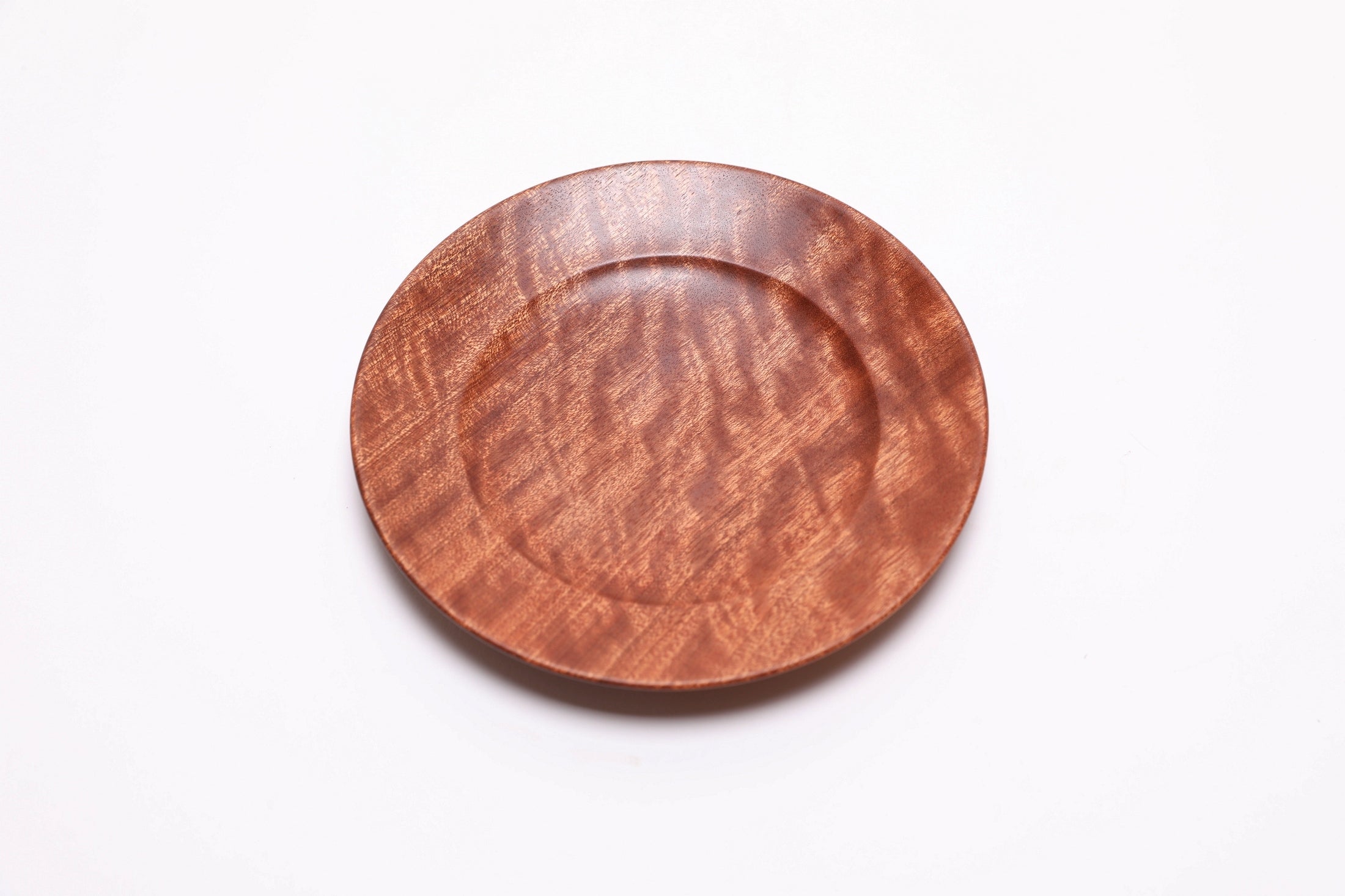 Wooden ring dish in quilted sapele, top view rotated 30°, curved taper and undercut rim visible