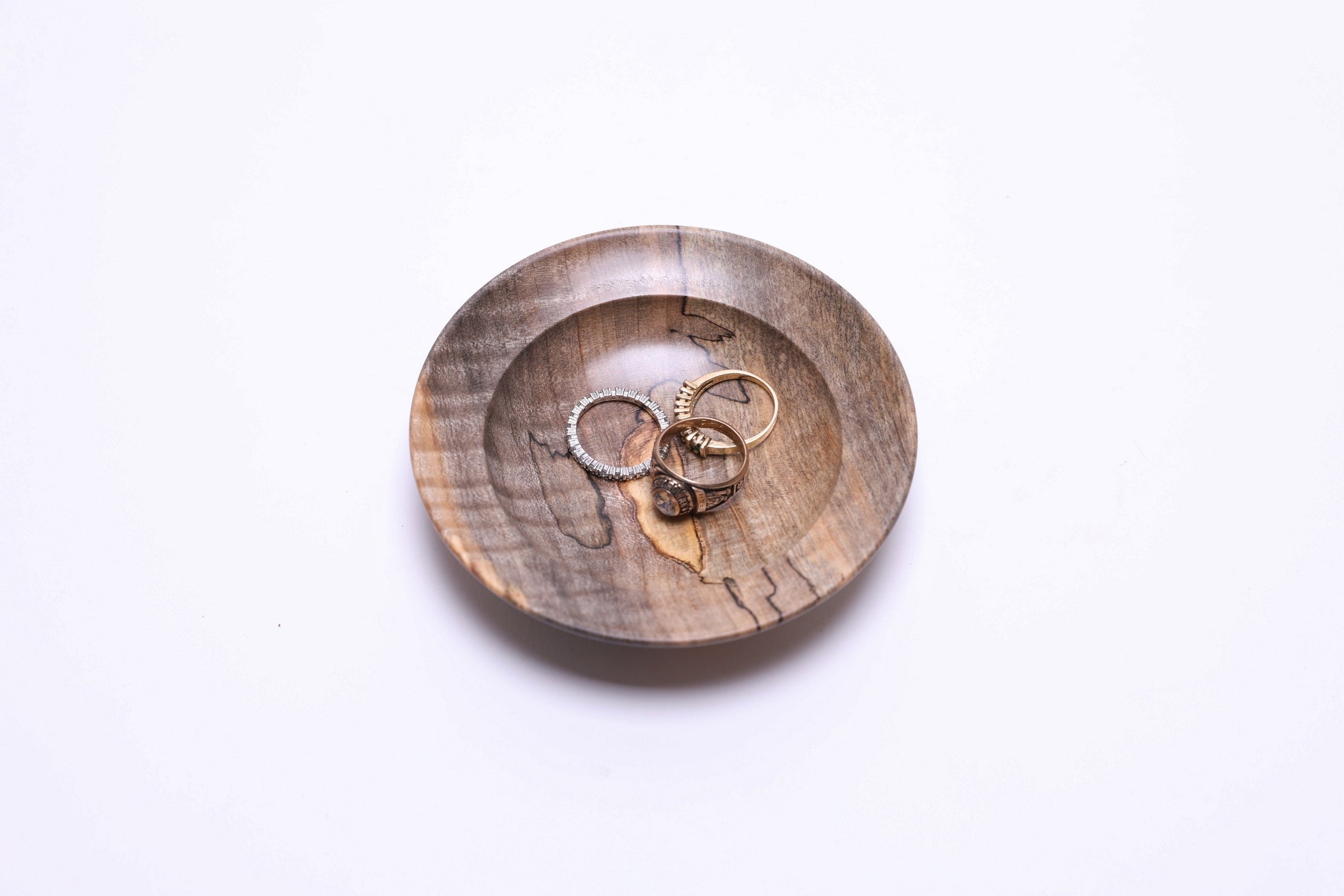 Top view of spalted tiger maple ring dish with three rings for scale, 4⅛" diameter