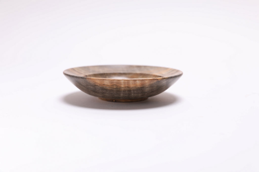 Side view of spalted tiger maple ring dish showing curved taper, undercut rim, and raised foot