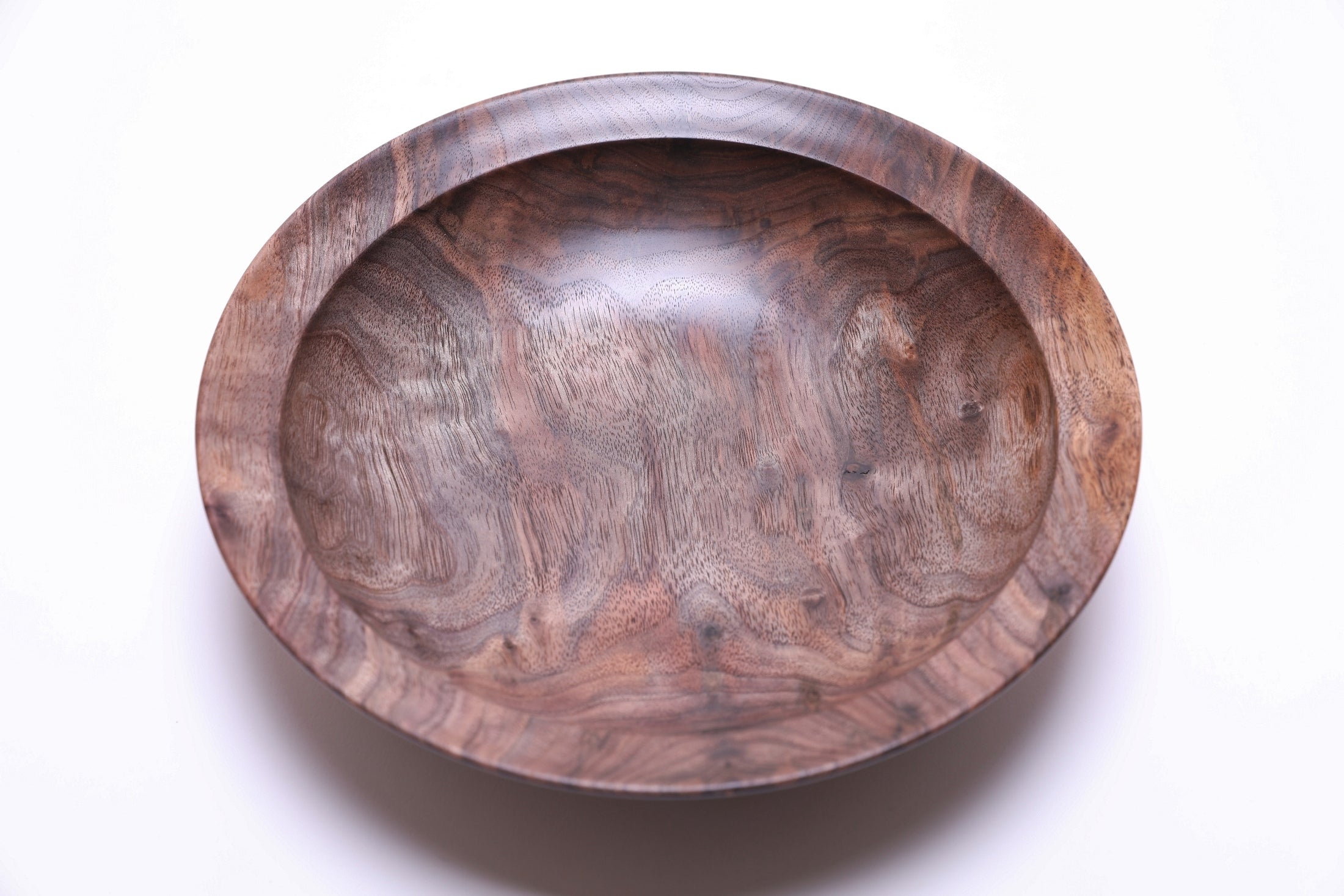 Curly wild black walnut wooden bowl top view rotated 90 degrees — curly grain figure with gray, tan, and milk chocolate coloration, multiple bud scar halos visible across the surface