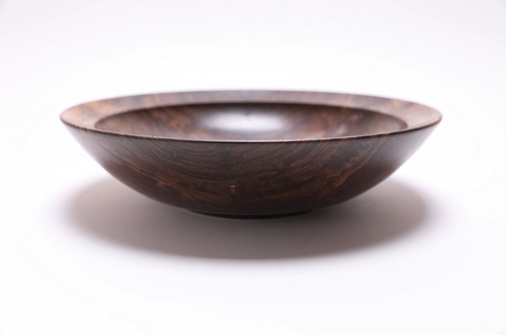  Curly wild black walnut wooden bowl side view — rounded curved taper with undercut rim and raised foot, dark chocolate and copper tones, food-safe oil finish