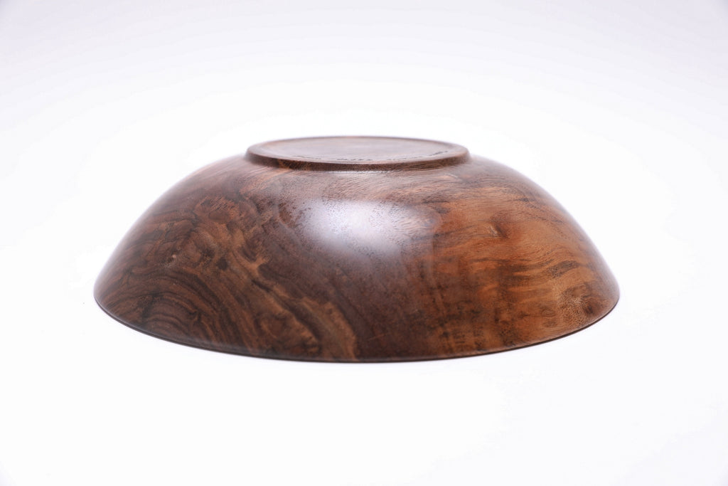 Curly wild black walnut wooden bowl bottom view — raised foot construction, natural wood grain on base, handcrafted in NC by Sanders Woodworking