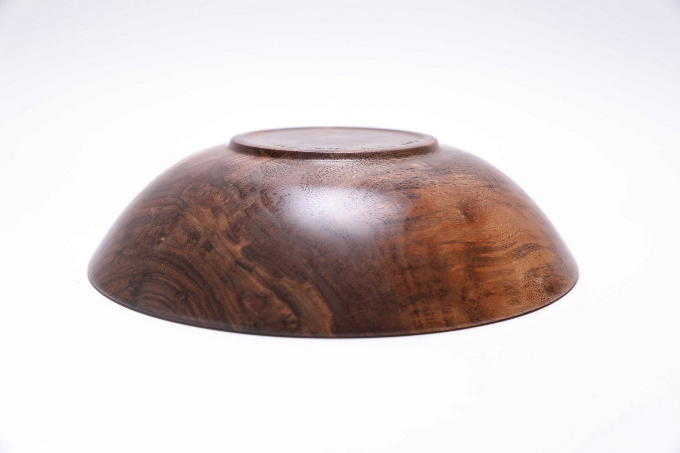 Curly wild black walnut wooden bowl bottom view — raised foot construction, natural wood grain on base, handcrafted in NC by Sanders Woodworking