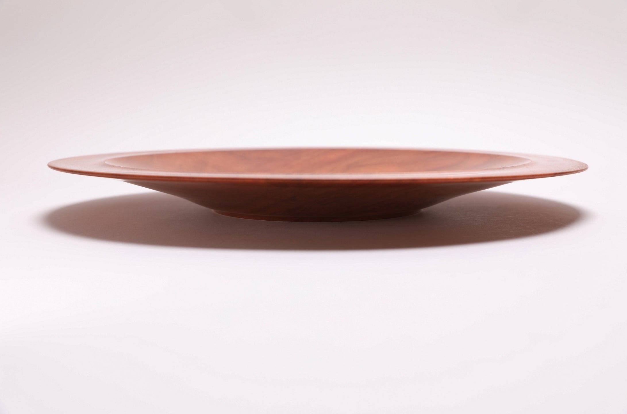 Wild black cherry wooden platter — side view, showing curved taper, raised foot, and 1.5" depth
